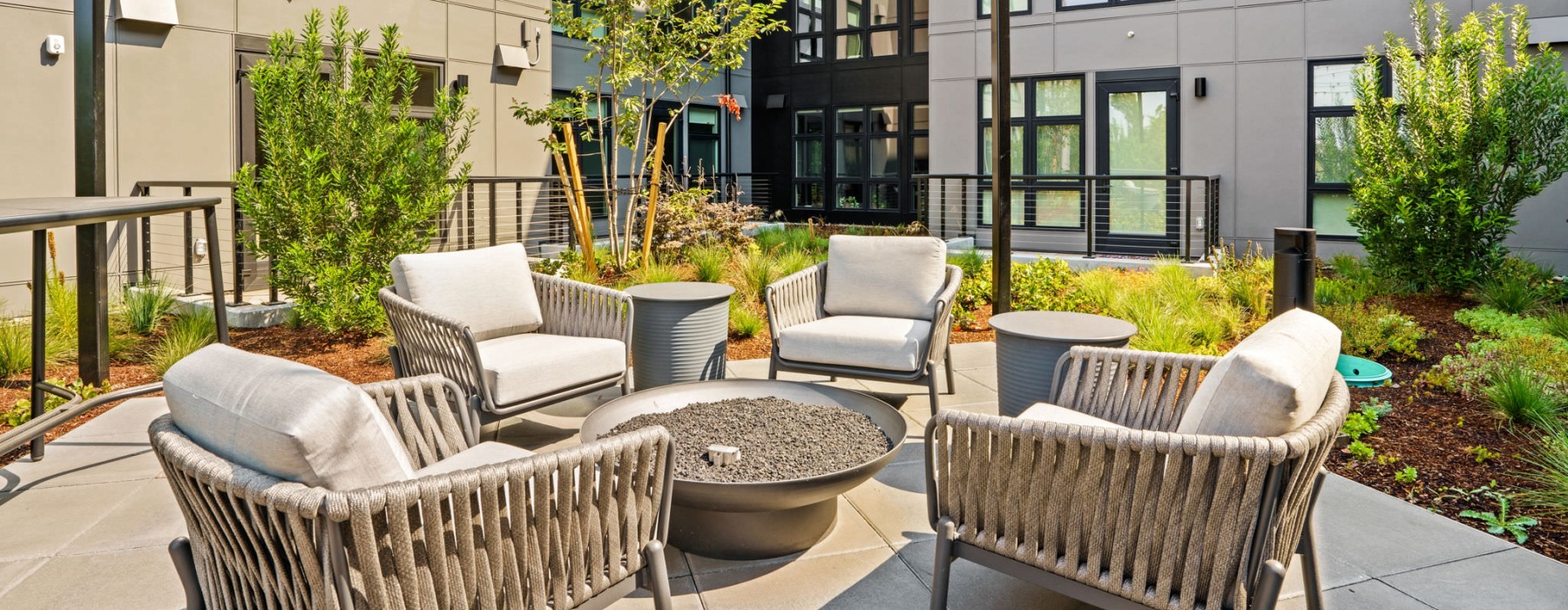 a patio with a fire pit and chairs