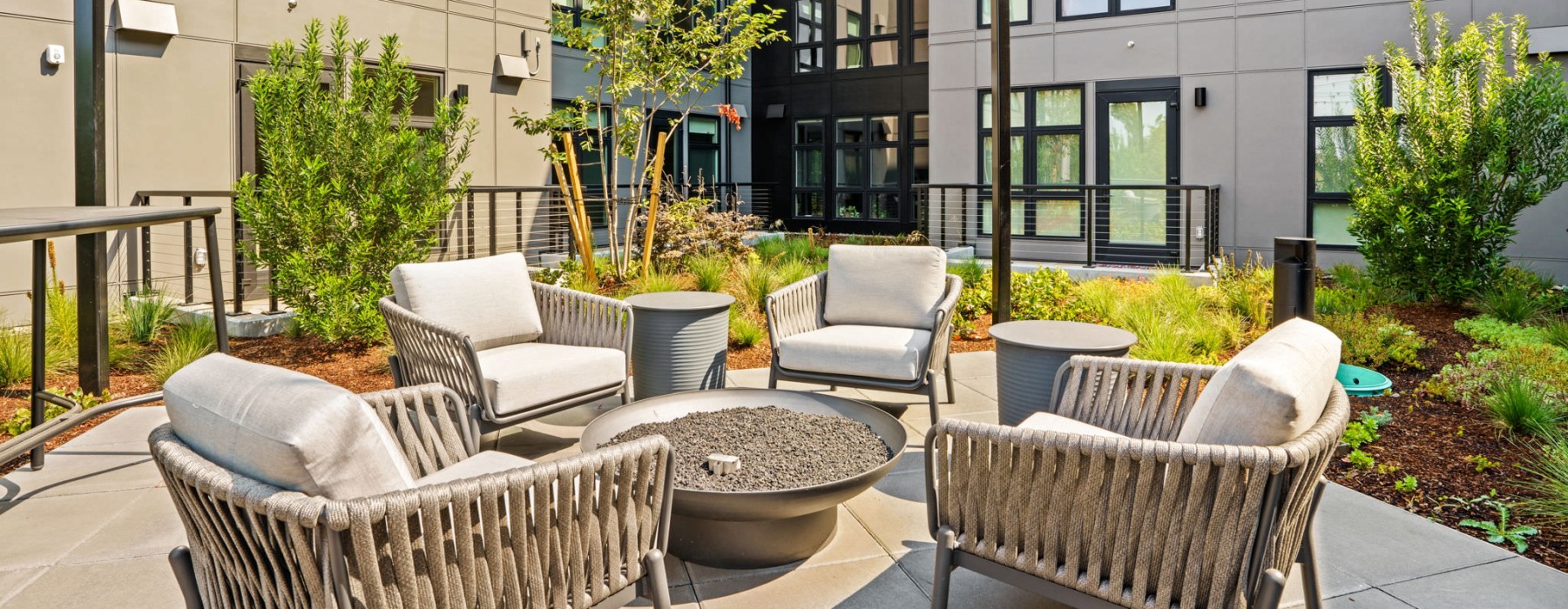 a patio with a fire pit and chairs