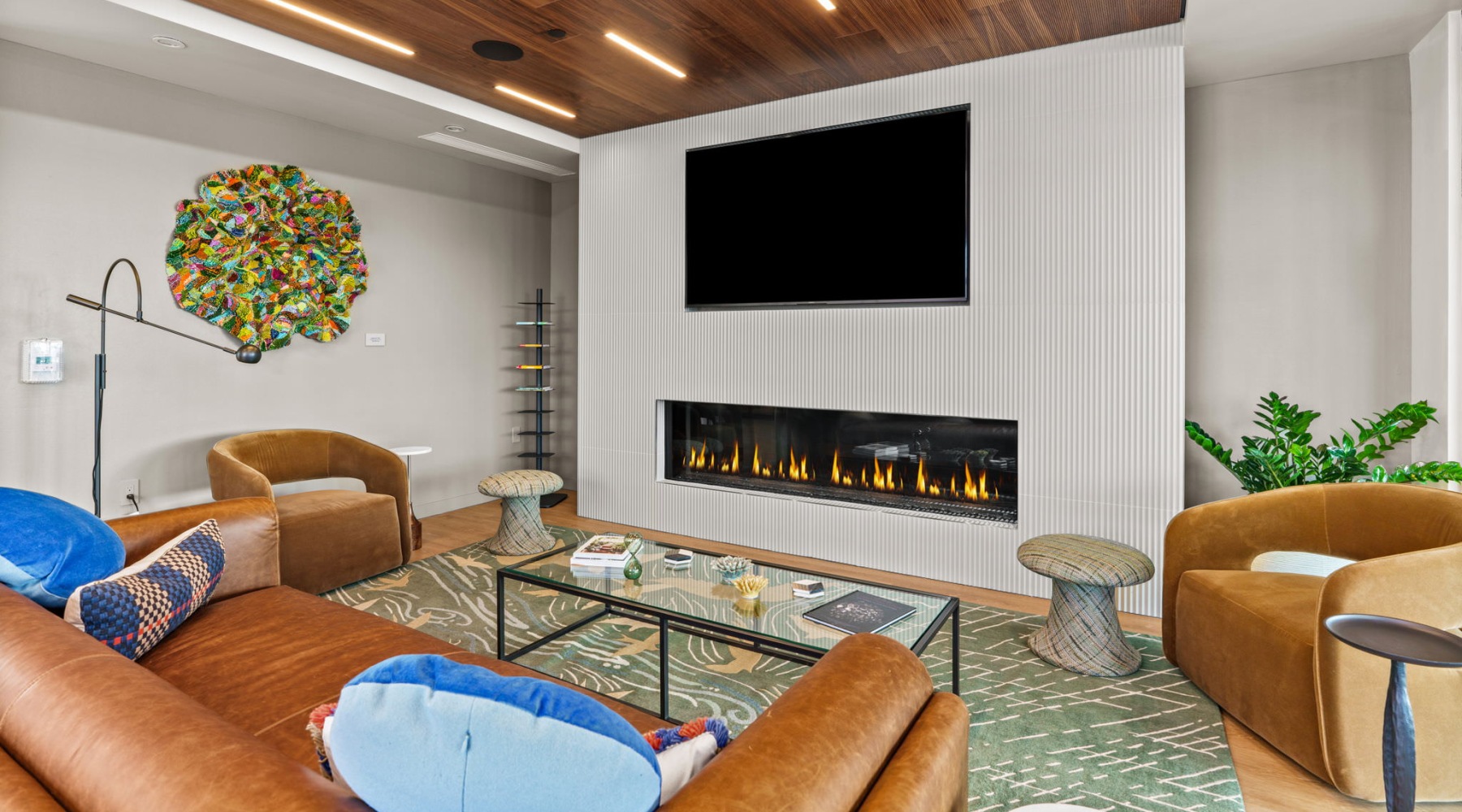a clubroom with a couch, tv and fireplace