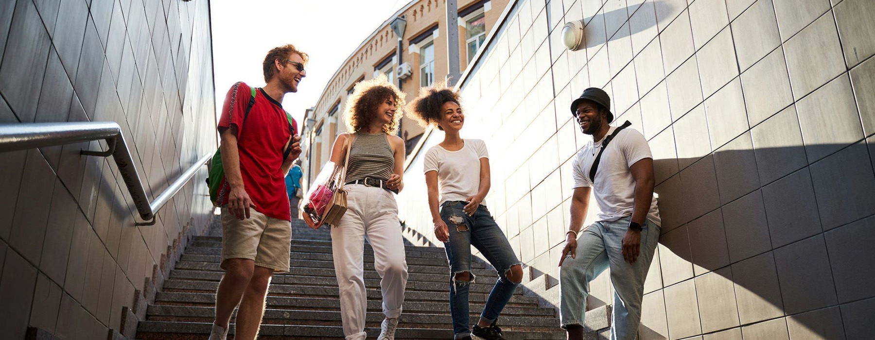 A group of people walking down the stairs to public transportation.